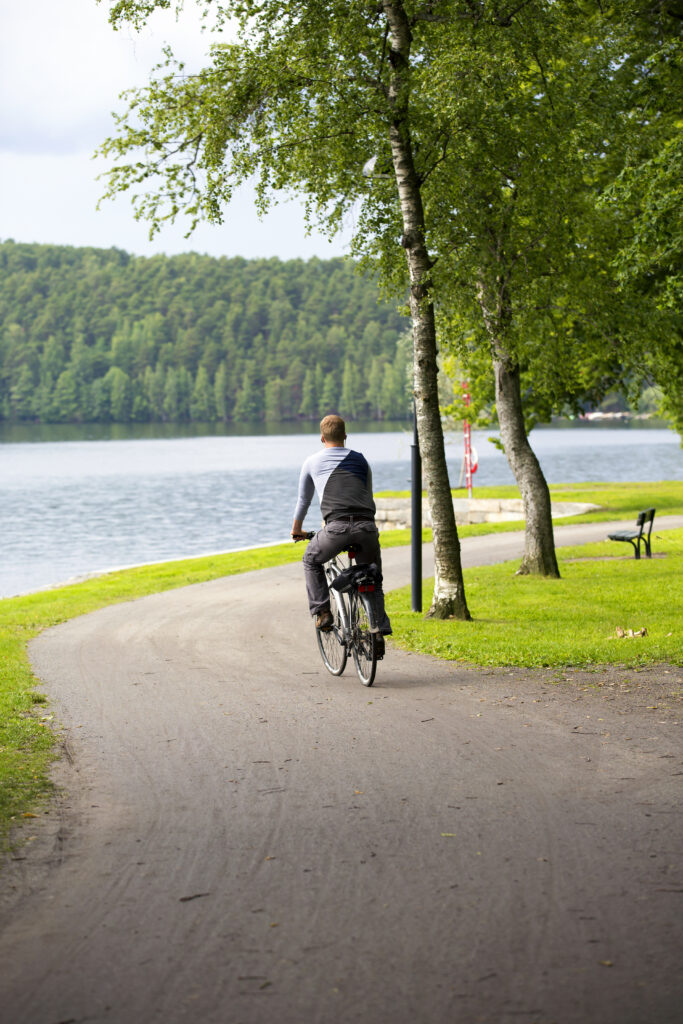 Homme faisant du vélo au bord de l'eau à Dagneux, illustrant l'environnement naturel proche de la résidence Le Zéphir.