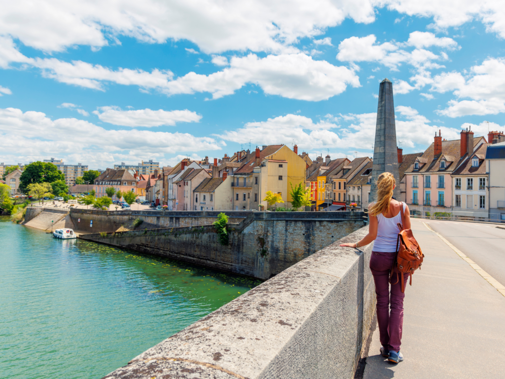 Vue aérienne du village de Fontaines-sur-Saône, de la Saône et du programme Hameau de Montgay, avec la skyline de Lyon visible à l'horizon.